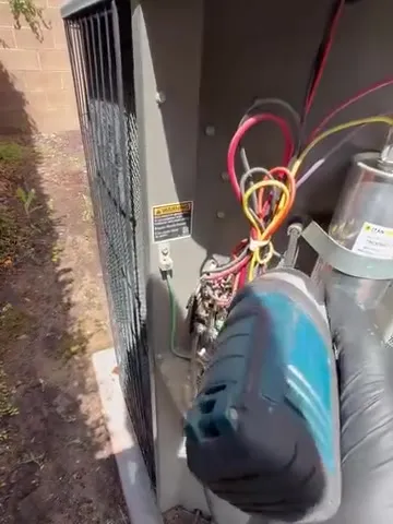 AC condenser with the access panel off for a capacitor replacement
